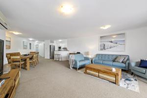 a living room with a blue couch and a table at Flightdeck 101, Clarence Street in Port Macquarie