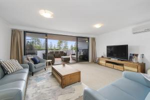 a living room with a couch and a tv at Flightdeck 101, Clarence Street in Port Macquarie