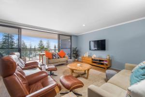 a living room with furniture and a large window at Flightdeck 301, Clarence Street in Port Macquarie