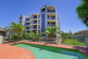 a apartment building with a swimming pool in front of a building at Flightdeck 301, Clarence Street in Port Macquarie