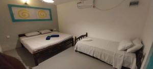 a small room with two beds and a picture on the wall at Sun Rock Villa Arugambay in Arugam Bay
