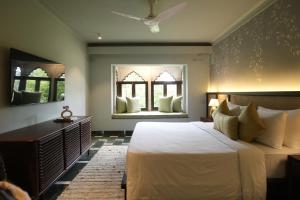 a bedroom with a large bed and two windows at YAAN Udaipur in Udaipur