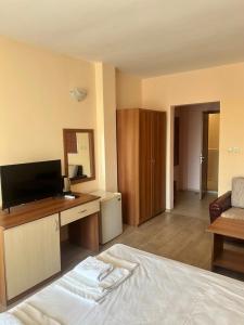 a bedroom with a bed and a desk with a television at Ryor Hotel - Restaurant & Free Parking in Sunny Beach