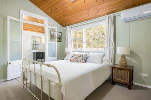 a bedroom with a white bed and a window at Historic Huntingdon House in Wauchope