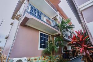a pink house with a balcony and plants at Douglas Luxury Apartments - Douglas Court in Trofwi
