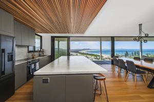 a kitchen and dining room with a view of the ocean at La Mer, 19 Dulconghi Street in Crescent Head