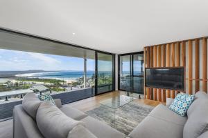 a living room with a large screen tv and a couch at La Mer, 19 Dulconghi Street in Crescent Head