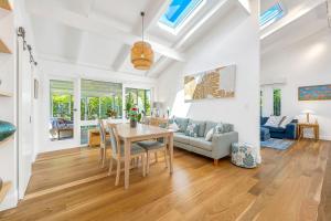 a dining room and living room with a table and chairs at Lighthouse Beach Luxury in Port Macquarie