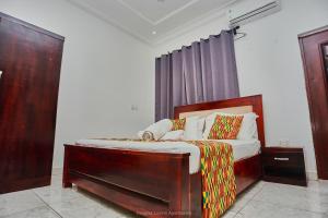 a bedroom with a bed with a wooden frame at Douglas Luxury Apartments - Douglas Court in Trofwi +37 photos