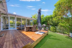 a patio with an umbrella and a table and chairs at Lighthouse Beach Luxury in Port Macquarie