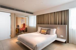 a bedroom with a large bed and a desk at Ovolo Central in Hong Kong