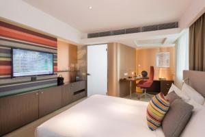 a hotel room with a bed and a flat screen tv at Ovolo Central in Hong Kong