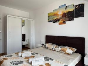 a bedroom with a bed with three pictures on the wall at APARTMaN HAPPY PLACE in Soko Banja
