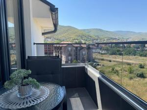 a table and a chair on a balcony with a view at APARTMaN HAPPY PLACE in Soko Banja