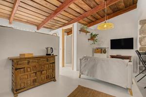 a living room with a wooden dresser and a tv at La Paredita Casa Acentejo in Tanque