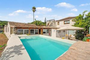 a swimming pool in front of a house at La Paredita Casa Acentejo in Tanque