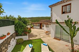 a house with a yard with chairs and a garden at La Paredita Casa Acentejo in Tanque