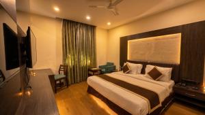 a hotel room with a bed and a television at Hotel Las Vegas in Jaipur +7 photos
