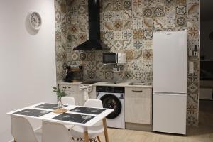 a kitchen with a table and a white refrigerator at Los Llanos Loft & Suites in Manzanilla