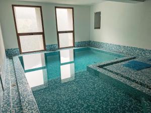 a bathroom with a swimming pool with two windows at Apartment Casa del Bitto by Interhome in Pedesina