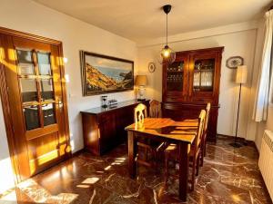 a dining room with a wooden table and chairs at Casa rural Lomalinda in Granada