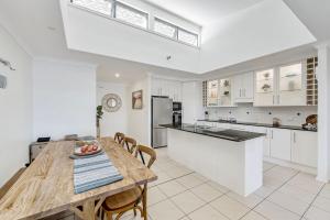 a kitchen and dining room with a wooden table and chairs at Pippies, your water view escape in North Haven