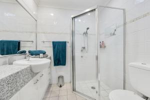 a white bathroom with a shower and a sink at Pippies, your water view escape in North Haven +14 photos