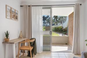 a home office with a desk and a sliding glass door at Relax at Flynn s View in Port Macquarie +11 photos