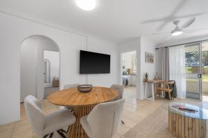 a living room with a table and chairs and a tv at Relax at Flynn s View in Port Macquarie
