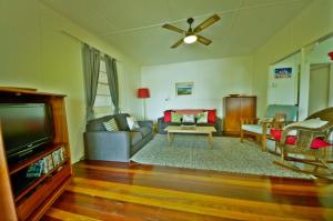 a living room with a couch and a tv at Rosemaree, 24 East Street in Crescent Head
