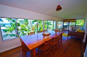 a dining room with a large wooden table and chairs at Rosemaree, 24 East Street in Crescent Head