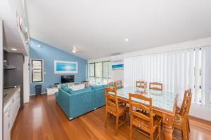 a living room with a table and a blue couch at Sandy Shores, Serenity Resort in Diamond Beach