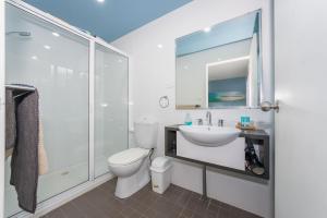 a bathroom with a toilet and a sink and a shower at Sandy Shores, Serenity Resort in Diamond Beach +15 photos