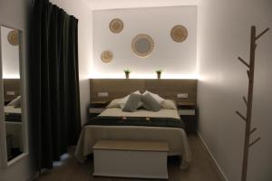 a bedroom with a bed and two mirrors on the wall at Los Llanos Loft & Suites in Manzanilla