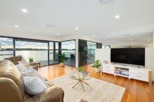 a living room with a large flat screen tv at Riverside Luxury in Port Macquarie