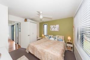 a bedroom with a bed and a ceiling fan at Sandy Shores, Serenity Resort in Diamond Beach