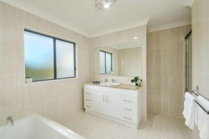 a bathroom with a tub and a sink and a mirror at Riverside Luxury in Port Macquarie +23 photos