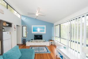 a living room with blue walls and a ceiling fan at Sandy Shores, Serenity Resort in Diamond Beach