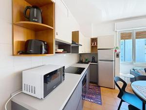 a kitchen with a microwave on a counter with a refrigerator at Apartment Ca dei Noni by Interhome in Riva del Garda