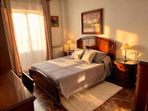 a bedroom with a bed and two lamps and a window at Casa rural Lomalinda in Granada