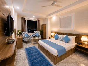 a bedroom with a bed and a tv and a couch at Hotel LA Meridian, A Luxury Hotel In Haridwar in Haridwār