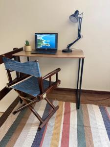 a desk with a chair and a laptop computer on it at Duplex 450m da Praia do Peró, Roupa Cama e Banho, Wi-Fi, TV a Cabo, Estacionamento in Cabo Frio
