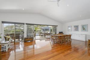 an empty living room with a table and chairs at Vaka Malua, 7 Scott Street in Crescent Head