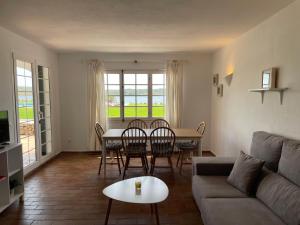 a living room with a couch and a table and chairs at Es CASTELL 03 by SOM Menorca in Fornells