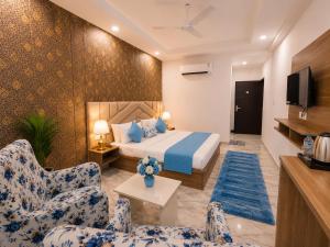 a hotel room with a bed and two chairs at Hotel LA Meridian, A Luxury Hotel In Haridwar in Haridwār