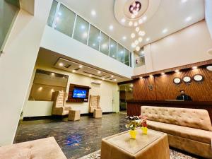 a lobby with a man sitting in a waiting room at Hotel LA Meridian, A Luxury Hotel In Haridwar in Haridwār