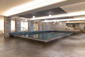 a hot tub in a room with a stone wall at Aktiv & Spa Hotel Alpenrose in Schruns