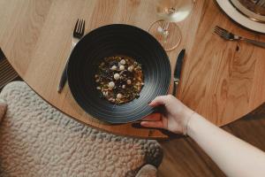 a person holding a plate of food on a table at Aktiv & Spa Hotel Alpenrose in Schruns