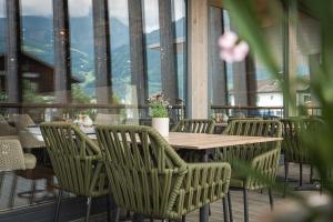 a wooden table and chairs on a balcony at Aktiv & Spa Hotel Alpenrose in Schruns +130 photos