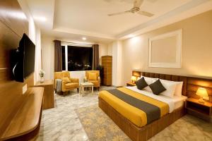 a hotel room with a bed and a chair at Hotel LA Meridian, A Luxury Hotel In Haridwar in Haridwār +24 photos